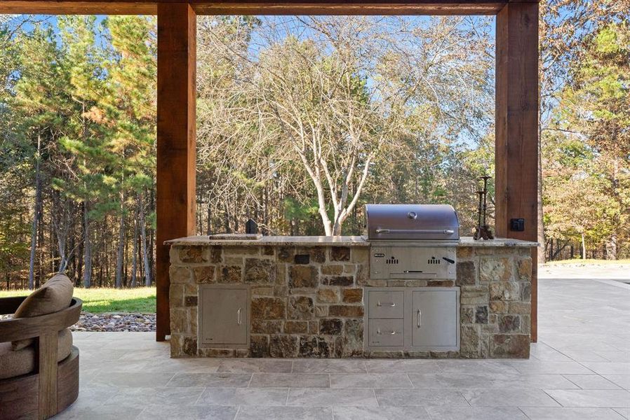 View of patio / terrace featuring exterior kitchen and view of wooded area