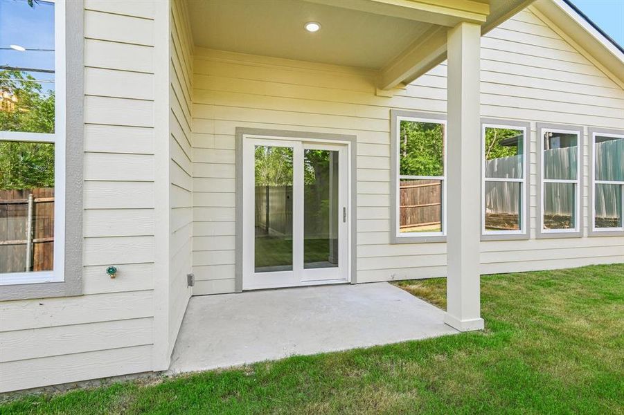 Rear exterior featuring siding, an attached patio, and multiple windows