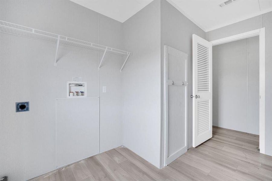 Laundry area featuring light wood-style flooring, electric dryer hookup, and hookup for a washing machine