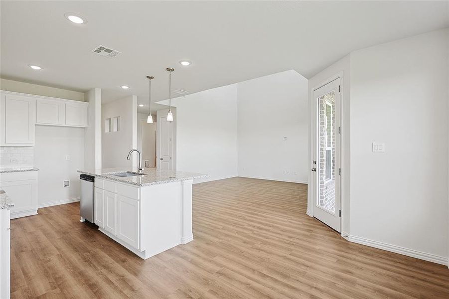 Kitchen with sink, white cabinets, and light hardwood / wood-style flooring