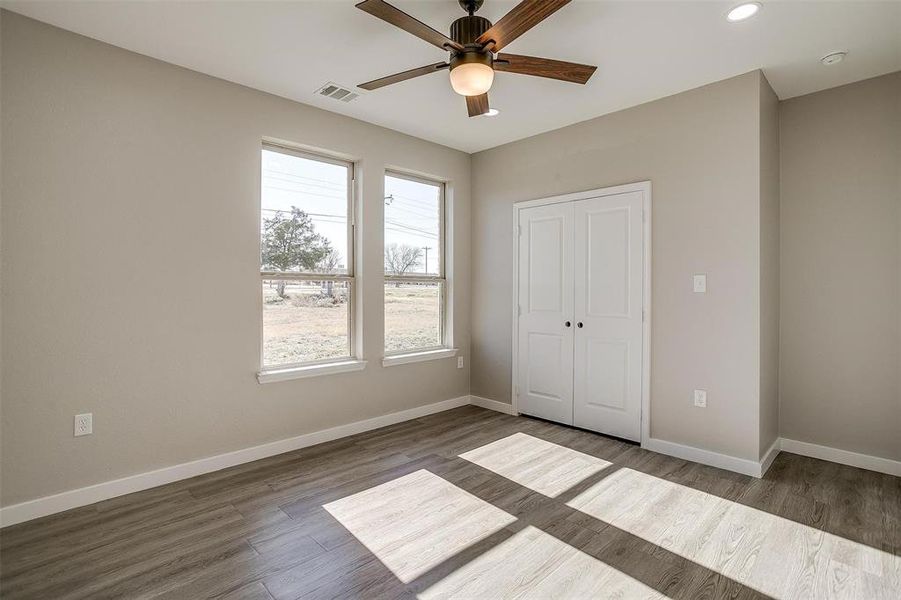 Unfurnished bedroom featuring ceiling fan, a closet, and dark wood-type flooring