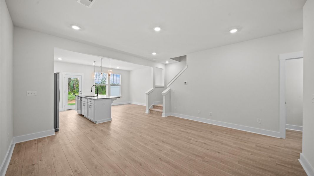 Spacious family room with rich hardwood flooring and elegant trim work in a reputable DRB Homes build Spacious family room with rich hardwood flooring and elegant trim work in a reputable DRB Homes build