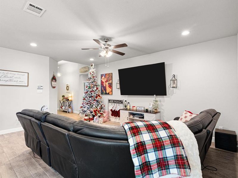 Living room with ceiling fan and light hardwood / wood-style floors