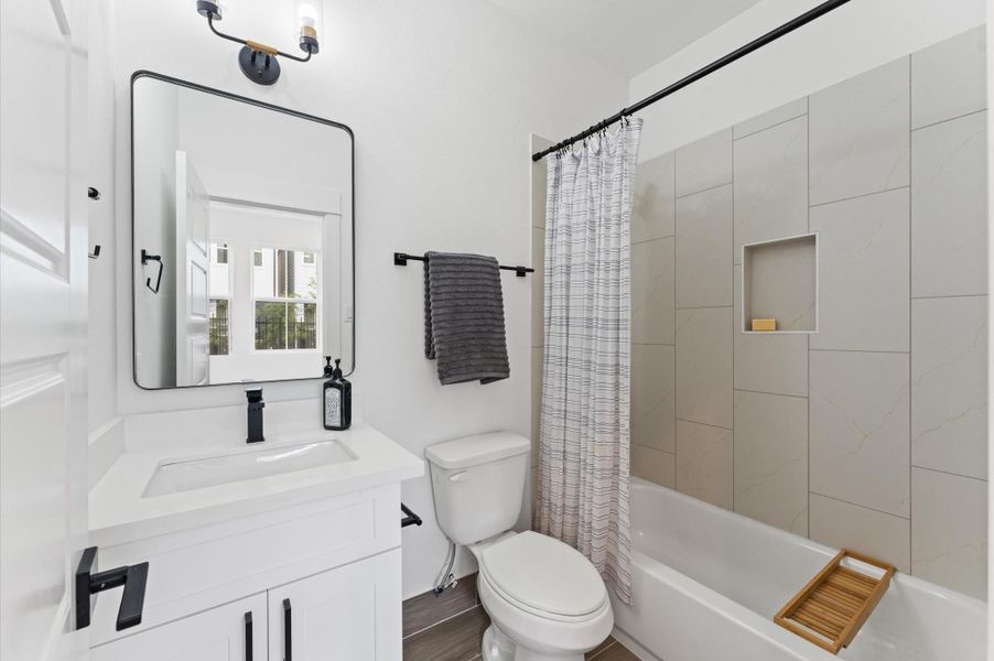 Conveniently located within the first-floor bedroom, this ensuite secondary bathroom offers both style and practicality. The tub-shower combo is framed with classic tilework and modern fixtures, making it ideal for quick rinses or relaxing soaks. Conveniently located within the first-floor bedroom, this ensuite secondary bathroom offers both style and practicality. The tub-shower combo is framed with classic tilework and modern fixtures, making it ideal for quick rinses or relaxing soaks.