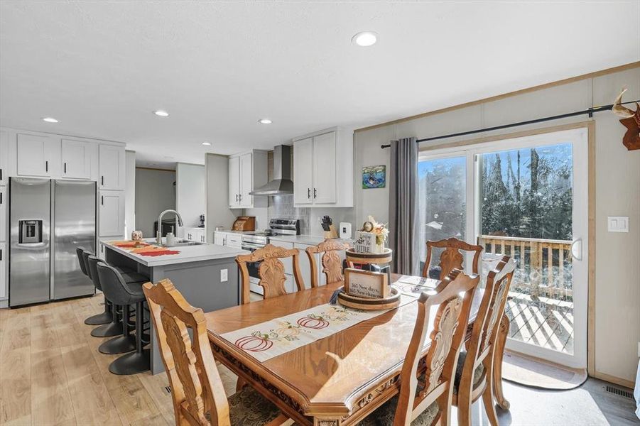 Dining room with light wood finished floors and recessed lighting Dining room with light wood finished floors and recessed lighting