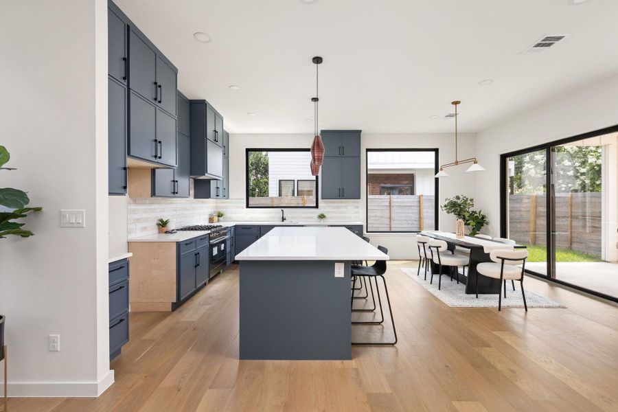 Culinary delights await in this modern kitchen with extensive counter space and an adjoining dining area.