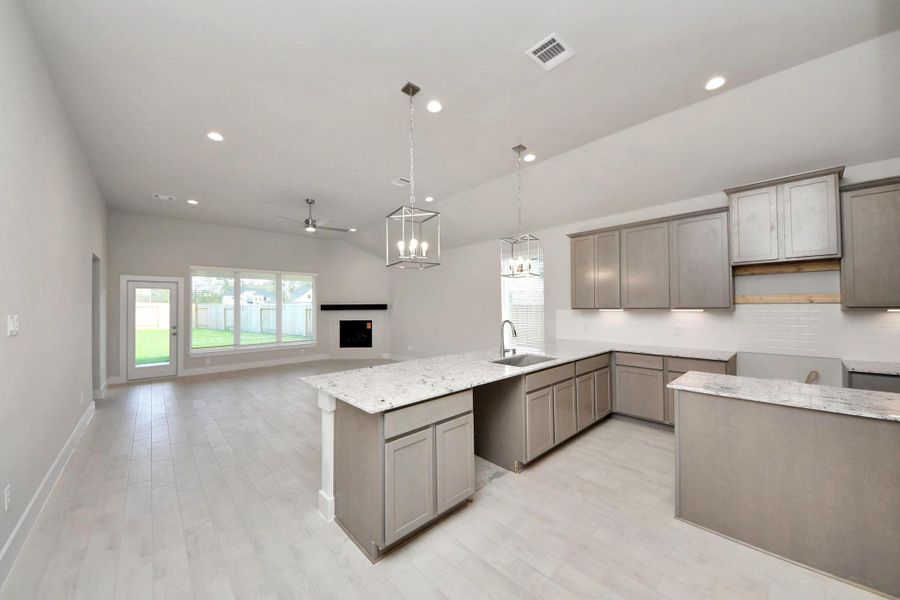 Step into a dream realized with this generously spacious kitchen! A massive granite island takes center stage, complemented by high ceilings and soft-close cabinets. The granite countertops, stainless steel appliances, sleek tile backsplash, and recessed lighting complete the elegant design. Sample photo of completed home with similar floor plan. Actual colors and selections may vary.