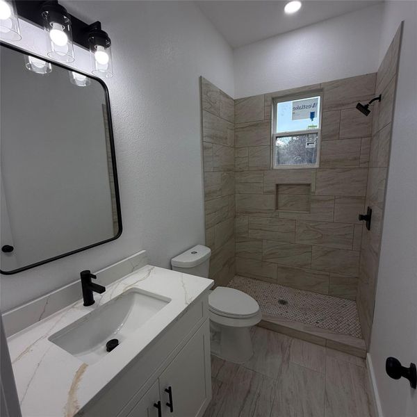 Vanity with a white countertop and integrated sink, matte black faucet, and a rectangular mirror
