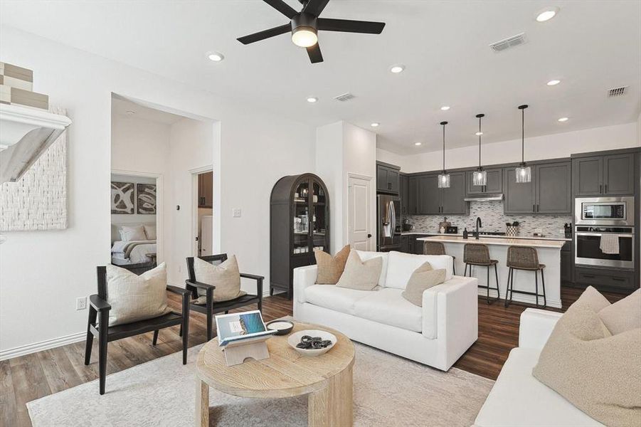 Living room with ceiling fan, sink, and hardwood / wood-style flooring