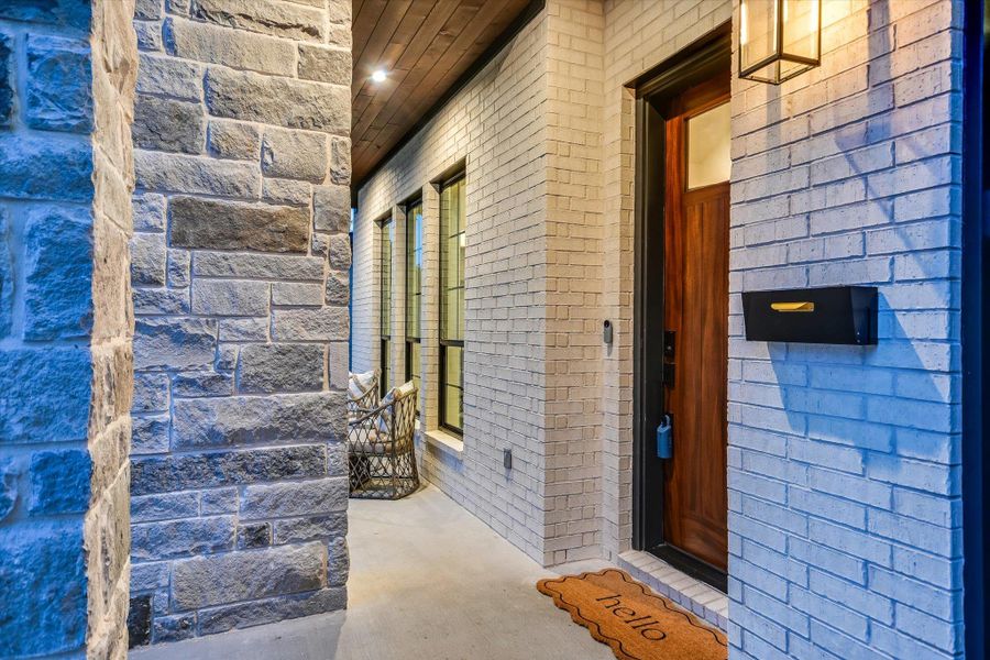 A welcoming covered front entry featuring a rich wooden door framed by brick and stone. A welcoming covered front entry featuring a rich wooden door framed by brick and stone.