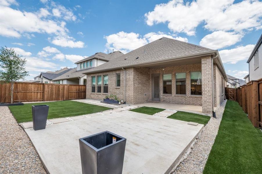 Back of house with a patio, brick siding, roof with shingles, and a fenced backyard Back of house with a patio, brick siding, roof with shingles, and a fenced backyard