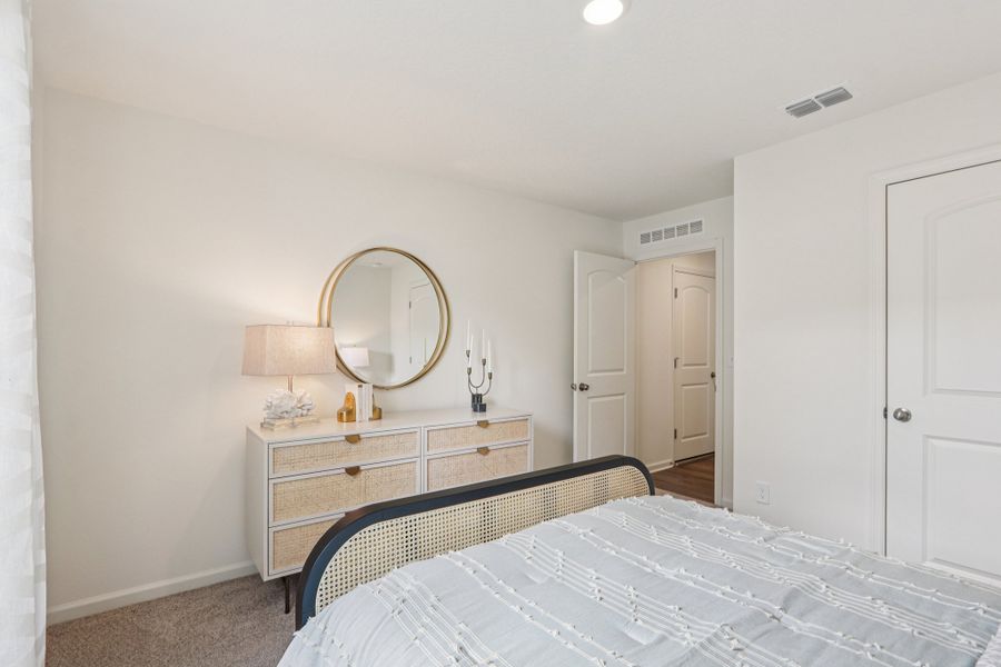 A bedroom with a mirror and a bed. A bedroom with a mirror and a bed.