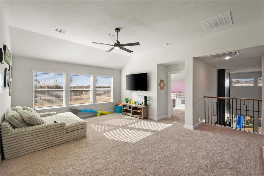 Game room with lofted ceiling, a ceiling fan, and carpet flooring