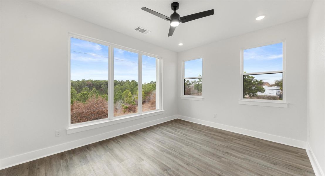 Spare room with wood finished floors, a ceiling fan, and recessed lighting