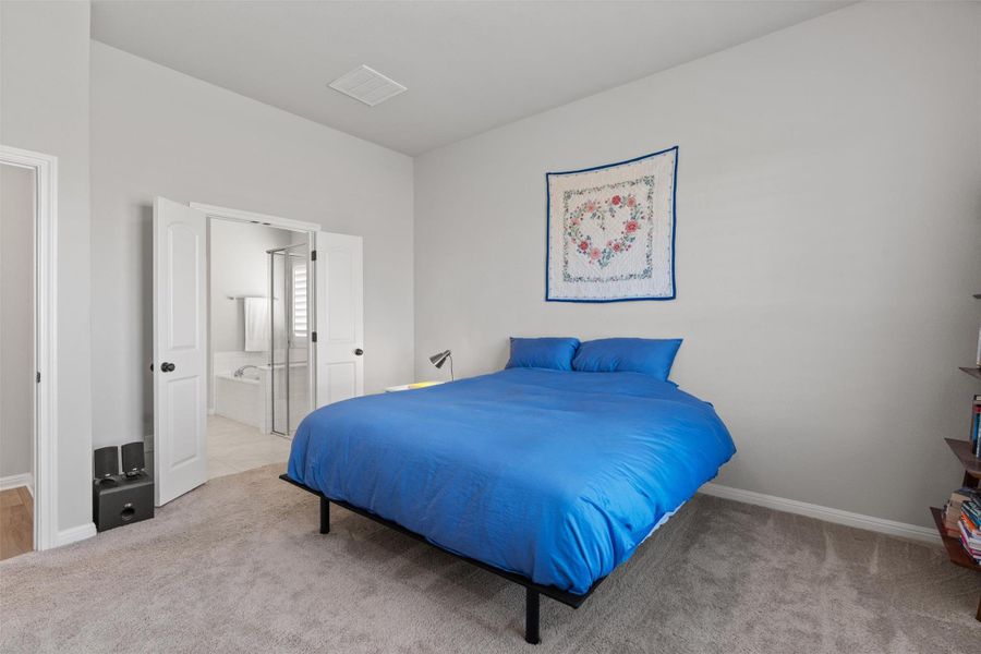 Primary bedroom: French doors lead into the spacious bathroom.