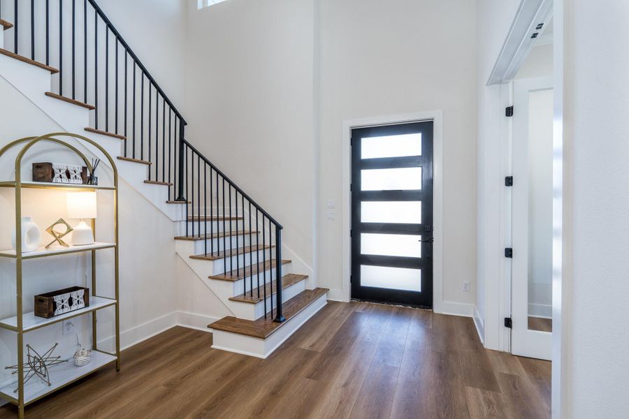 Modern entry with black front door, staircase, and sleek metal railings. This area is bright and welcoming with clean lines and designer touches. Modern entry with black front door, staircase, and sleek metal railings. This area is bright and welcoming with clean lines and designer touches.