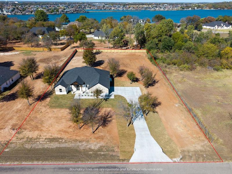 Aerial view of property and surrounding area with property parcel outlined and a nearby body of water