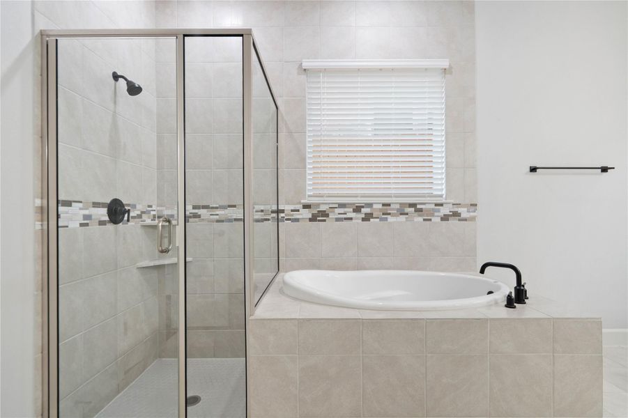 Tiled walls and a deep soaking tub highlight this contemporary bathroom layout.