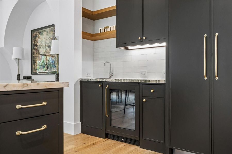 Wet Bar with marble counter, floating white oak wood shelves, sink and beverage refrigerator Wet Bar with marble counter, floating white oak wood shelves, sink and beverage refrigerator
