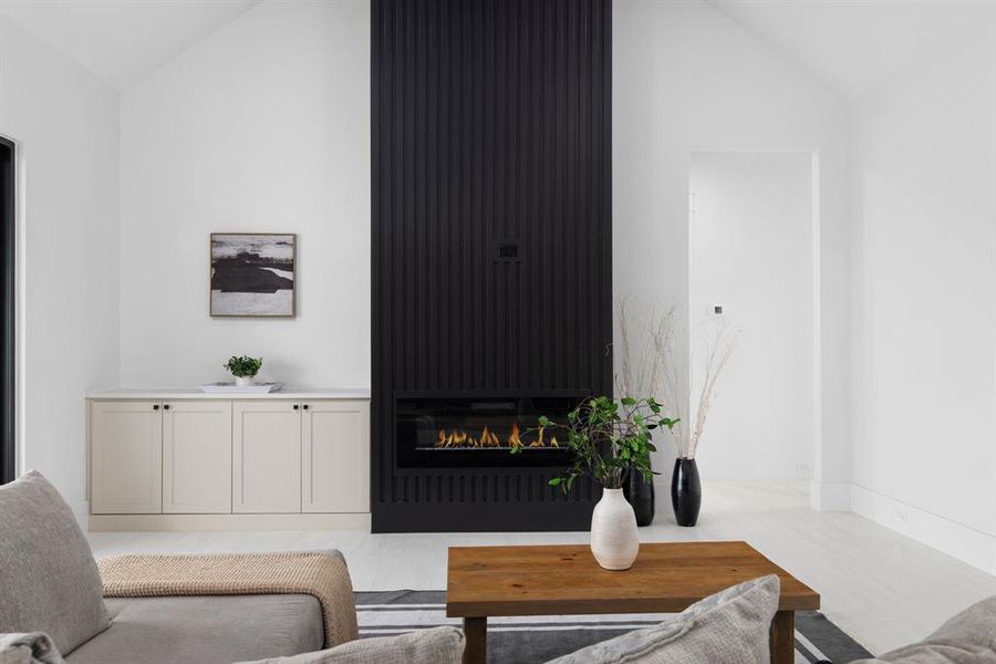 Living room featuring lofted ceiling and a large fireplace