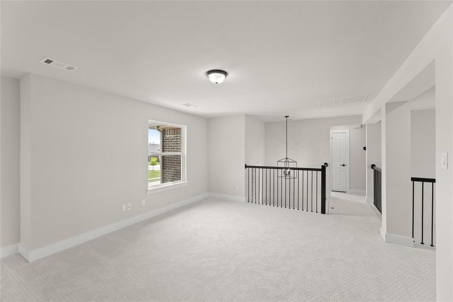 Spare room with light carpet, visible vents, and baseboards