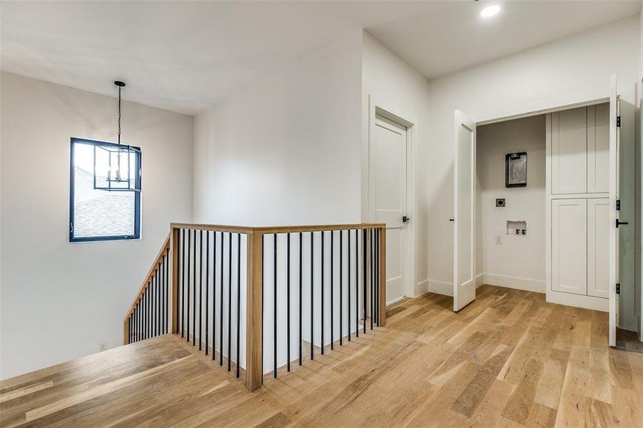 Hall featuring a chandelier and light hardwood / wood-style flooring