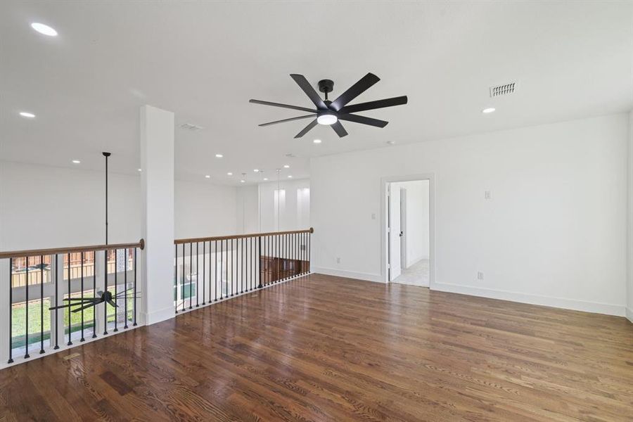 Empty room featuring dark wood-type flooring, a ceiling fan, and recessed lighting
