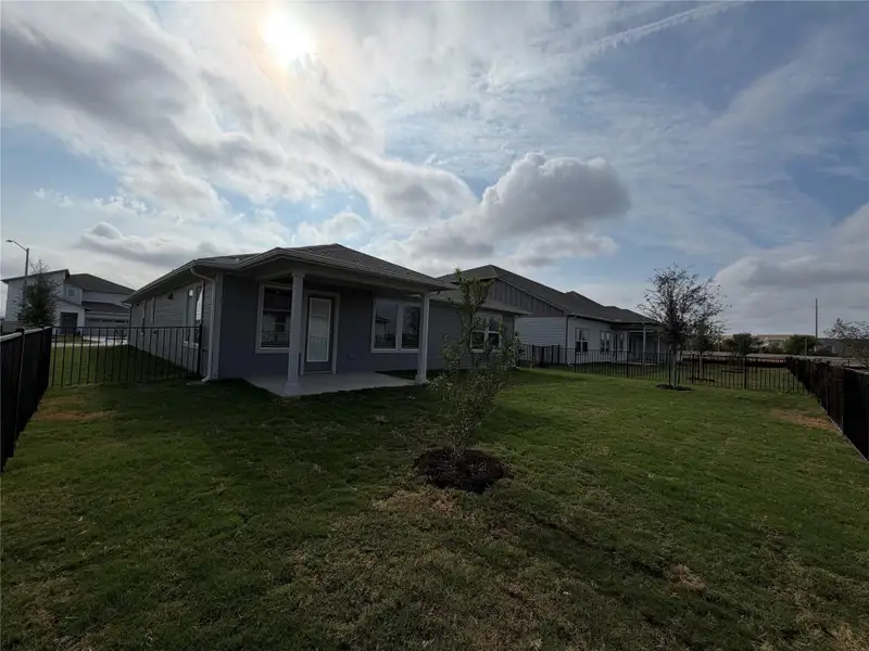 Back of property featuring a fenced backyard and a patio