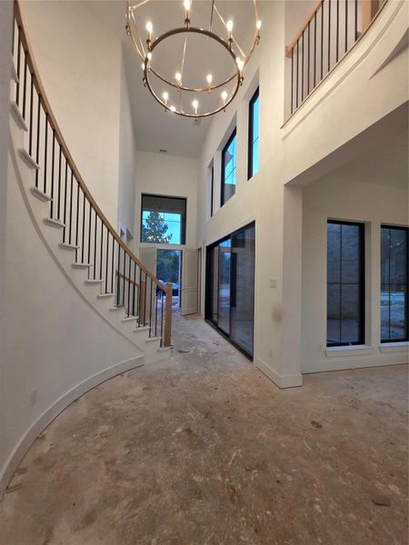Beautiful light fixture and curved stairs upon entering.