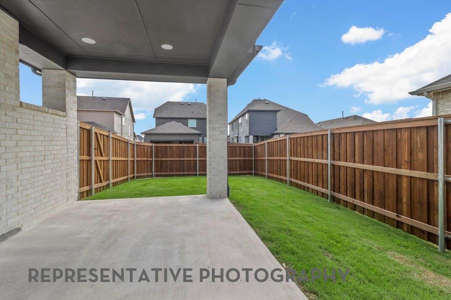 The covered patio, accented with a sturdy brick pillar, provides a charming and sheltered space perfect for gathering and enjoying the outdoors.