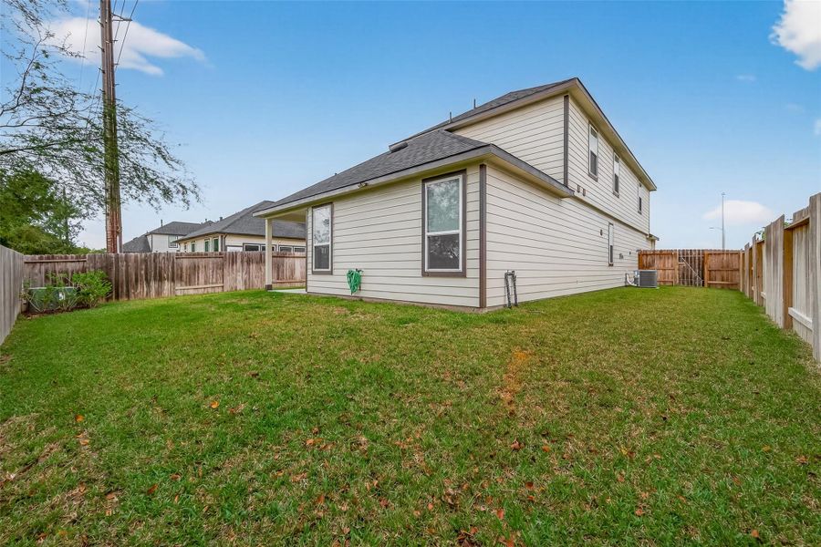A full view of the backyard shows the open outdoor space along with the rear of the house.