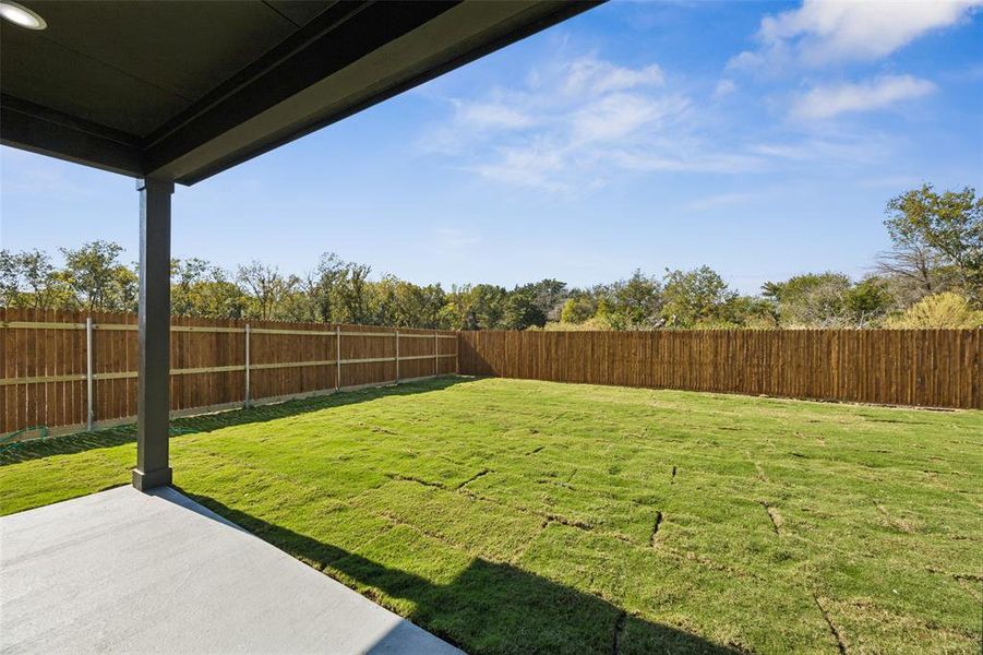 Fenced backyard with a patio