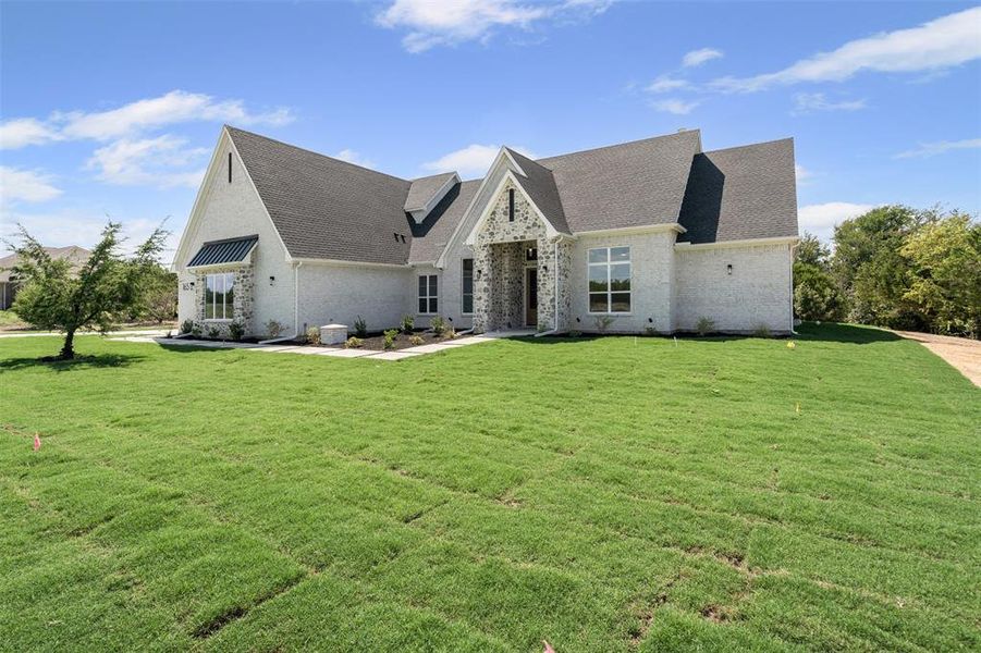 French provincial home with brick siding, a shingled roof, and a front lawn French provincial home with brick siding, a shingled roof, and a front lawn