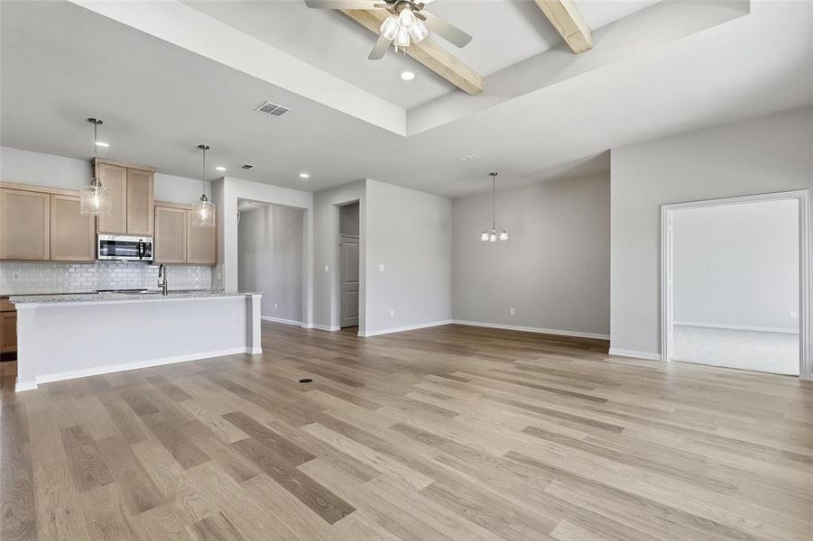 Unfurnished living room with beam ceiling, light wood-style floors, a ceiling fan, and recessed lighting Unfurnished living room with beam ceiling, light wood-style floors, a ceiling fan, and recessed lighting