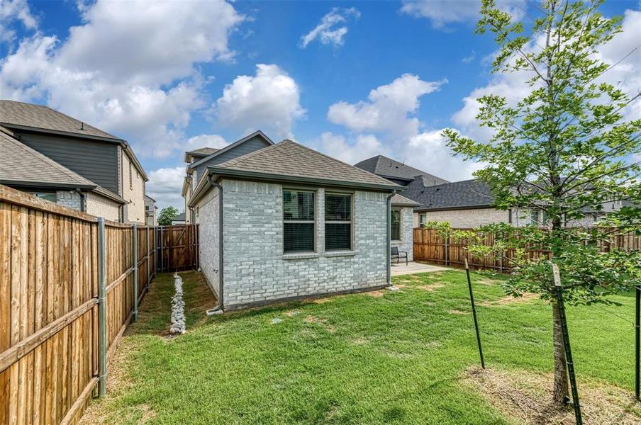 Rear view of property with roof with shingles, brick siding, a fenced backyard, and a patio area Rear view of property with roof with shingles, brick siding, a fenced backyard, and a patio area
