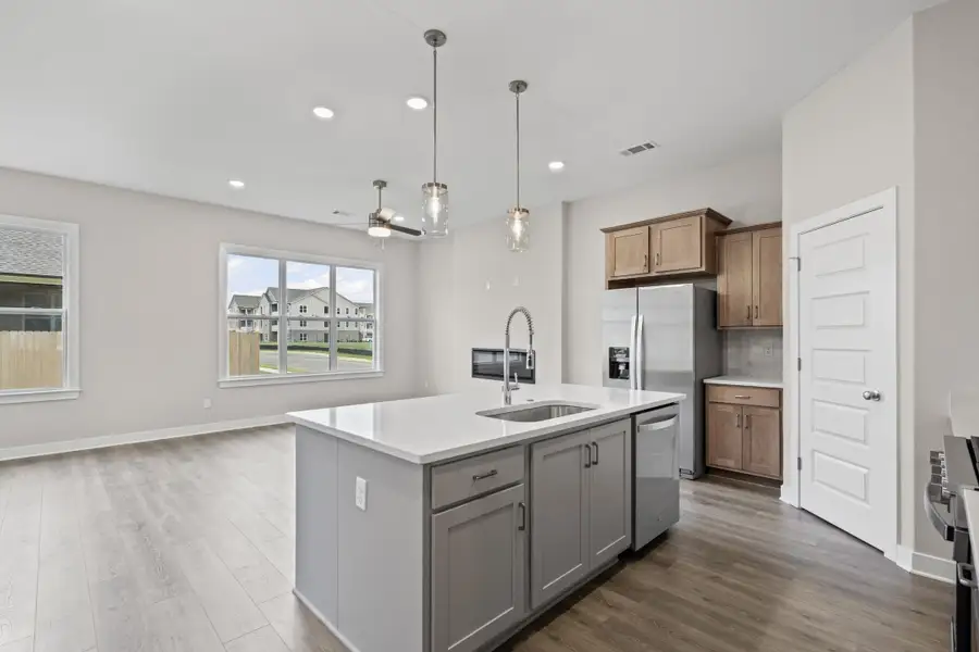 Kitchen with pendant lighting, a kitchen island with sink, gray cabinetry, dark wood finished floors, and recessed lighting