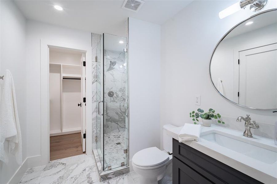 Bathroom with walk in shower, vanity, and toilet