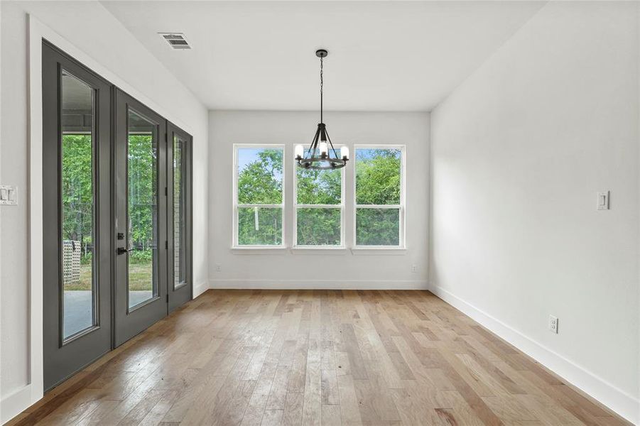 Unfurnished dining area with a chandelier and light wood-style flooring