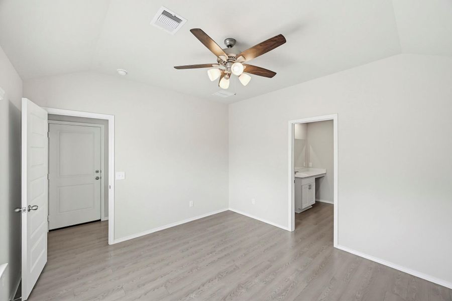 Primary Bedroom. The en-suite bathroom is just to the right, and to the left is access to the backyard.