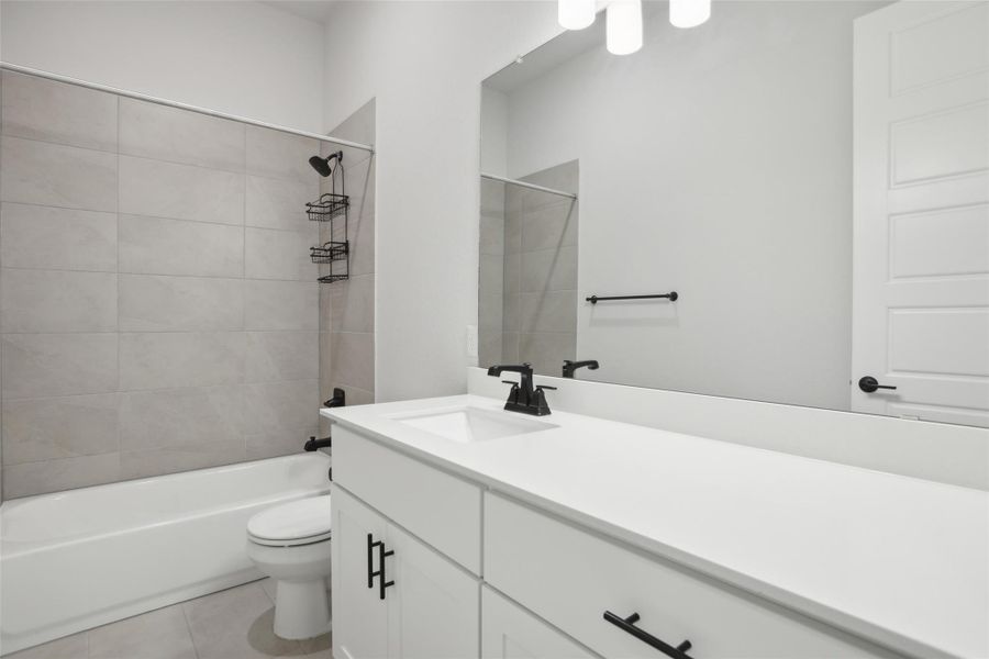 Full bath featuring shower / bath combination, vanity, toilet, and tile patterned floors