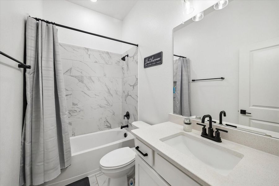 Beautifully appointed secondary bathroom featuring quartz countertops, modern fixtures, and a clean, timeless design. Beautifully appointed secondary bathroom featuring quartz countertops, modern fixtures, and a clean, timeless design.