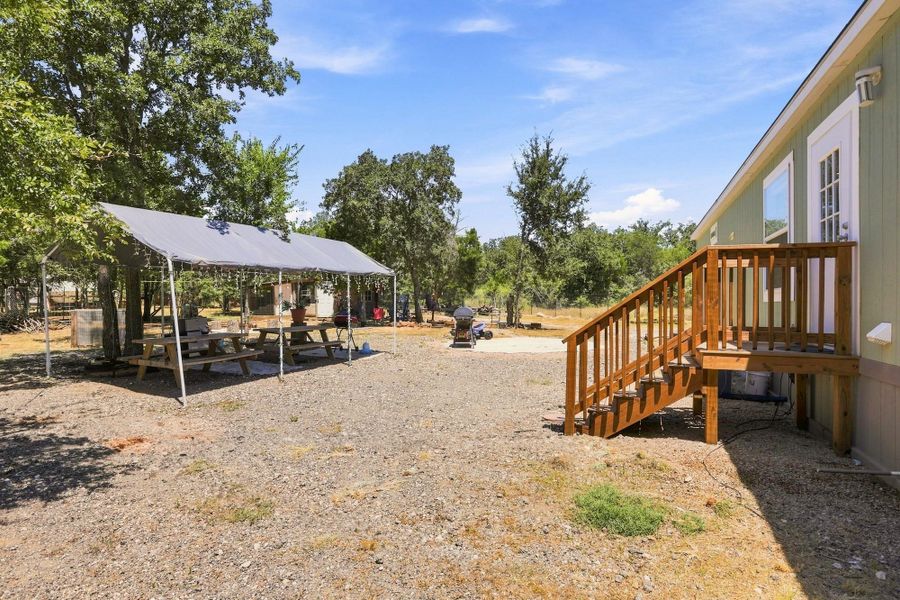 Wooden steps descend to a gravel yard offering plenty of open space.