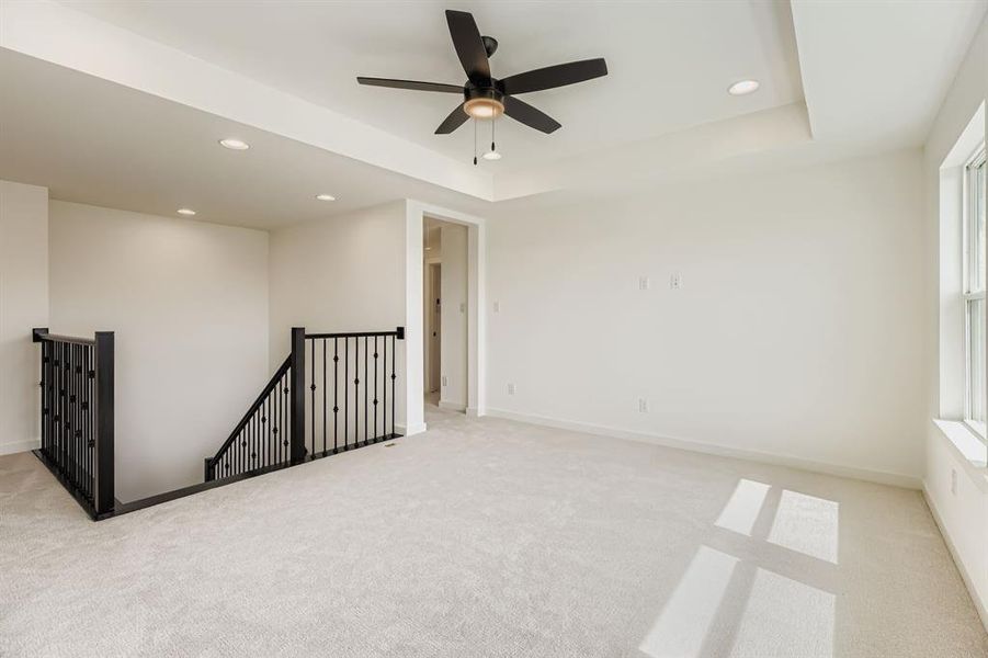 Spare room featuring light carpet, recessed lighting, a tray ceiling, and a ceiling fan
