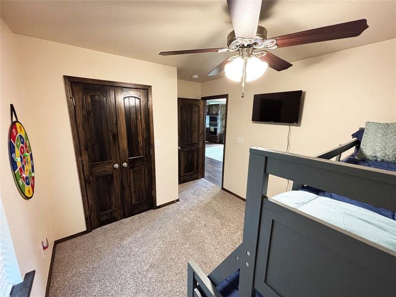Bedroom featuring a closet, light carpet, and ceiling fan Bedroom featuring a closet, light carpet, and ceiling fan