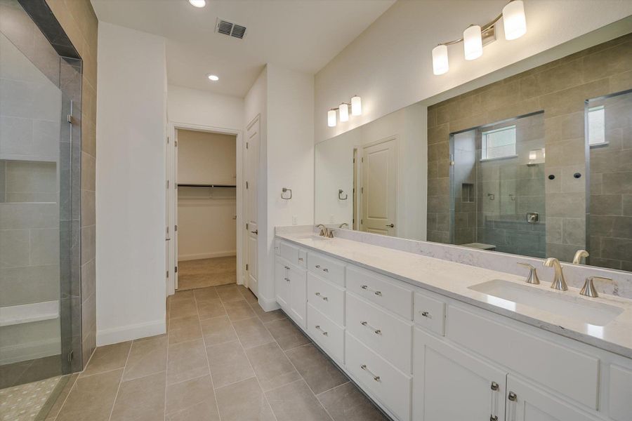 Full bathroom featuring double vanity, a shower stall, tile patterned flooring, recessed lighting, and a spacious closet Full bathroom featuring double vanity, a shower stall, tile patterned flooring, recessed lighting, and a spacious closet