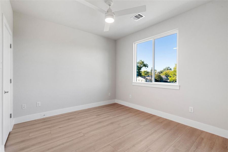 Secondary bedroom with tall windows, ceiling fan and clean architectural lines. Secondary bedroom with tall windows, ceiling fan and clean architectural lines.