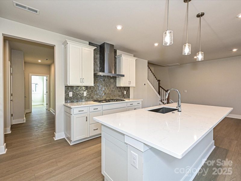 Quartz countertops and designer backsplash bring the space together.