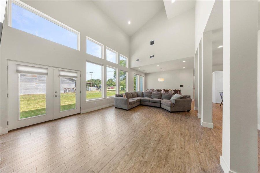 Living area with light wood-style flooring, french doors, recessed lighting, and lofted ceiling Living area with light wood-style flooring, french doors, recessed lighting, and lofted ceiling