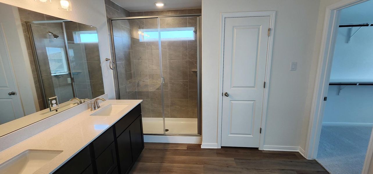 A well-appointed primary bathroom showcases a double vanity, a spacious walk-in shower, and contemporary finishes. A well-appointed primary bathroom showcases a double vanity, a spacious walk-in shower, and contemporary finishes.