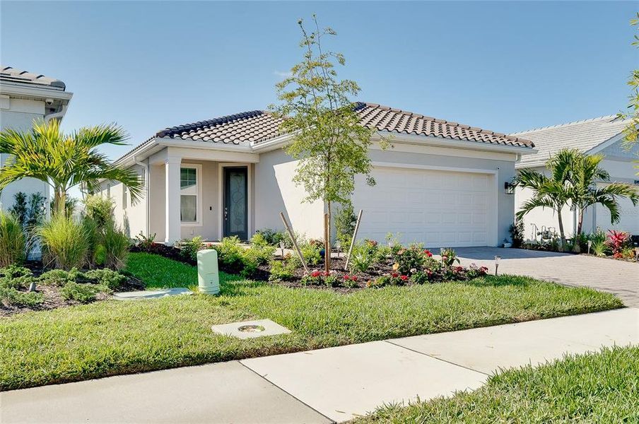 Front exterior of a new home in BeachWalk by Manasota Key, Englewood, FL, highlighting curb appeal (Image 28).